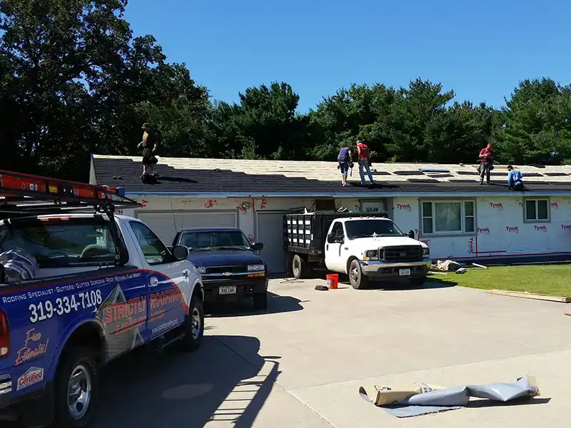 Crew installing new shingles on a roof